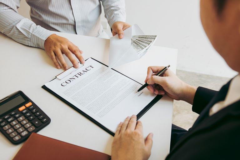 Dos personas llenando un contrato de un préstamo en efectivo