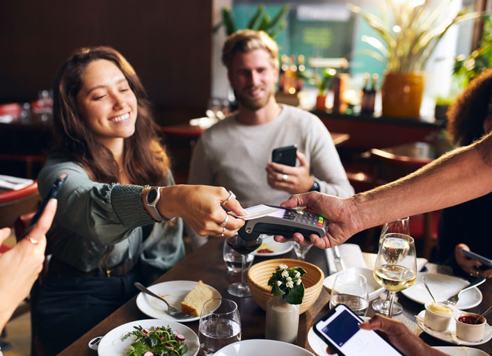 Mujer pagado la cuenta en un restaurante con tarjeta de credito