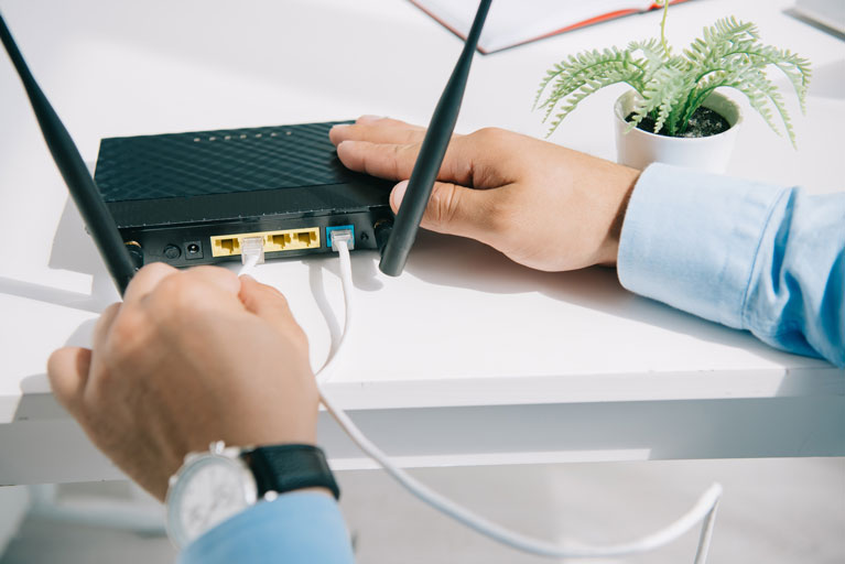 Hombre conectando un cable de internet a un modem